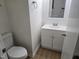 Half bathroom features a white vanity, toilet and light wood floors at 309 Wyatts Pond Lane, Cary, NC 27513
