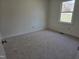 This cozy bedroom features neutral carpeting and a window for natural light at 309 Wyatts Pond Lane, Cary, NC 27513