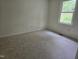 This cozy bedroom features neutral carpeting and a window for natural light at 309 Wyatts Pond Lane, Cary, NC 27513