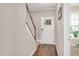 Hallway with wood-look flooring, carpeted stairs, and a traditional white front door at 31 Pascoli Ct, Clayton, NC 27527