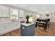 Open kitchen featuring white cabinets, island with seating, and stainless steel appliances next to dining area at 31 Pascoli Ct, Clayton, NC 27527