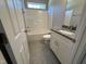 Bright bathroom featuring white cabinets, granite countertop and shower-tub combination at 311 W Market St, Graham, NC 27253