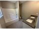 A bathroom featuring a bathtub, granite countertop with dual sinks, and tile floor at 311 W Market St, Graham, NC 27253