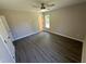 A bedroom featuring gray wood-look flooring, neutral paint, white trim, and a ceiling fan at 311 W Market St, Graham, NC 27253