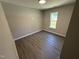 A bedroom featuring gray wood-look flooring, neutral paint, and white trim at 311 W Market St, Graham, NC 27253