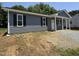 New construction home with gray siding, black shutters, and a gravel driveway at 311 W Market St, Graham, NC 27253