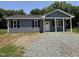 Charming home featuring gray siding, black shutters, and a welcoming front porch area at 311 W Market St, Graham, NC 27253