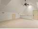 Bonus room with neutral carpet, white walls, a ceiling fan, attic doors, and a short railing at 3124 Briar Stream Run, Raleigh, NC 27612