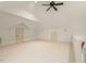 Bonus room with light carpet, white walls, ceiling fan, attic doors, and access to a stairway at 3124 Briar Stream Run, Raleigh, NC 27612