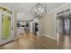 Dining area with access to kitchen and sitting room, hardwood floors, and chandelier at 3124 Briar Stream Run, Raleigh, NC 27612