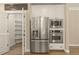 Stainless steel refrigerator and appliances stand next to a walk-in pantry in this well-lit and open kitchen at 3124 Briar Stream Run, Raleigh, NC 27612