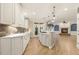 This kitchen features white cabinets, stone countertops, stainless appliances and an island cooktop open to the Gathering room at 3124 Briar Stream Run, Raleigh, NC 27612