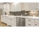 Farmhouse sink and stainless steel dishwasher are featured in this charming kitchen with white cabinets and marble countertops at 3124 Briar Stream Run, Raleigh, NC 27612