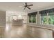 Spacious living room featuring hardwood floors, brick fireplace, ceiling fan and large windows for natural light at 3124 Briar Stream Run, Raleigh, NC 27612