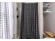 Bathroom featuring a patterned shower curtain, shelves with towels, and a small wooden stool at 3600 Star Trek Ct, Raleigh, NC 27604