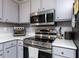 Close up of the kitchen with stainless steel oven, microwave, and grey cabinets at 3600 Star Trek Ct, Raleigh, NC 27604