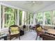 Relaxing screened porch with ceiling fan, wicker furniture, and views of lush greenery at 3600 Star Trek Ct, Raleigh, NC 27604
