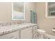 Well-lit bathroom featuring a granite countertop, white cabinets, and a decorative mirror at 40 Yellowstone Ct, Youngsville, NC 27596