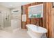 Modern bathroom with a free-standing tub, a walk-in shower, and an accent wall at 40 Yellowstone Ct, Youngsville, NC 27596