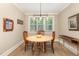 Inviting dining room with a round wooden table, stylish lighting, and large windows at 40 Yellowstone Ct, Youngsville, NC 27596