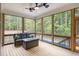 Relaxing sunroom with natural light, forest views, comfortable seating, and a ceiling fan for added comfort at 40 Yellowstone Ct, Youngsville, NC 27596