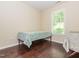 Bedroom featuring hardwood floors, neutral walls, and a window view of the outdoors at 4020 Mindspring Dr, Raleigh, NC 27610