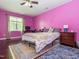 Bedroom featuring hardwood floors, a floral bedspread, pink walls, and a window view at 4020 Mindspring Dr, Raleigh, NC 27610