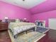 Bedroom featuring hardwood floors, a floral bedspread, and vibrant pink walls at 4020 Mindspring Dr, Raleigh, NC 27610