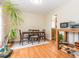 Bright dining room with wood floors, a wooden dining set, and a large leafy plant at 4020 Mindspring Dr, Raleigh, NC 27610