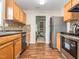 A full kitchen featuring stainless steel appliances, wood cabinets and flooring, and decorative backsplash at 4020 Mindspring Dr, Raleigh, NC 27610