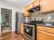 Well-lit kitchen with stainless steel appliances, wood cabinets, and decorative backsplash at 4020 Mindspring Dr, Raleigh, NC 27610