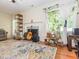 Cozy living room with wood flooring, fireplace, and a window with sheer curtains at 4020 Mindspring Dr, Raleigh, NC 27610