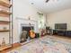 Cozy living room with fireplace, guitar, and bright window at 4020 Mindspring Dr, Raleigh, NC 27610