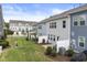 Backyard view of townhomes with a small patio and a grass area with minimal landscaping at 409 Rhamkatte Rd, Holly Springs, NC 27540