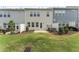 Backyard view of townhomes with a small patio and a grass area with minimal landscaping at 409 Rhamkatte Rd, Holly Springs, NC 27540