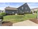 Backyard view of townhome featuring a grassy yard, patio and manicured shrubbery at 409 Rhamkatte Rd, Holly Springs, NC 27540