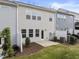 Backyard view of townhomes with a small patio and a grass area with minimal landscaping at 409 Rhamkatte Rd, Holly Springs, NC 27540