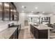 A kitchen with stainless steel appliances, dark wood cabinets, and granite countertops adjoins the living area at 409 Rhamkatte Rd, Holly Springs, NC 27540