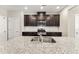 A bright kitchen with stainless steel appliances, dark wood cabinets, and granite countertops at 409 Rhamkatte Rd, Holly Springs, NC 27540