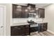 A bright kitchen with stainless steel appliances, dark wood cabinets, and granite countertops at 409 Rhamkatte Rd, Holly Springs, NC 27540