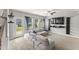 A bright living room features a gray sectional sofa, large windows, and outdoor access at 409 Rhamkatte Rd, Holly Springs, NC 27540