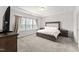 Serene main bedroom with a tray ceiling, large window, and plush carpeting at 409 Rhamkatte Rd, Holly Springs, NC 27540
