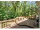 A spacious wooden backyard deck offers an inviting outdoor gathering area surrounded by mature trees and natural beauty at 4108 Lazyriver Ln, Durham, NC 27712