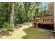 A wooden backyard deck with railings offers a tranquil outdoor space surrounded by lush greenery and mature trees at 4108 Lazyriver Ln, Durham, NC 27712