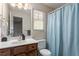 Bathroom features a sink, toilet, mirror and blue curtain at 4108 Lazyriver Ln, Durham, NC 27712