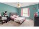 Bright bedroom features a teal wall, carpeted floor, ceiling fan, a bed and nightstand at 4108 Lazyriver Ln, Durham, NC 27712