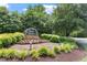 Stone entrance sign to Eno Trace framed by landscaping, flowers, bushes, trees, and mulch in a neighborhood at 4108 Lazyriver Ln, Durham, NC 27712