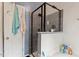 Modern bathroom with black framed glass shower, white vanity and blue accent wall, featuring stylish hardware at 4108 Lazyriver Ln, Durham, NC 27712