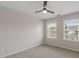 An empty carpeted bedroom features two windows and a ceiling fan at 4120 Overcup Oak Ln, Cary, NC 27519