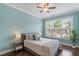 Charming bedroom with light blue walls, a cozy bed, large window, and ample natural light at 4120 Overcup Oak Ln, Cary, NC 27519